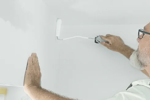 Person streicht Wand weiß